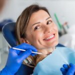 Eine Frau sitzt im Patientenstuhl beim Zahnarzt