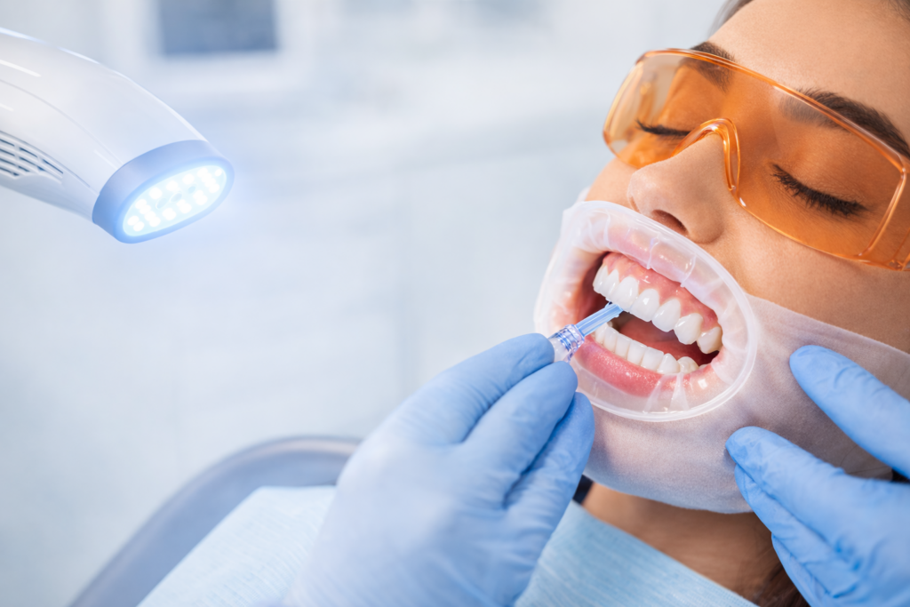 Patientin im Behandlungsstuhl mit Mundschutz beim Power-LED-Bleaching